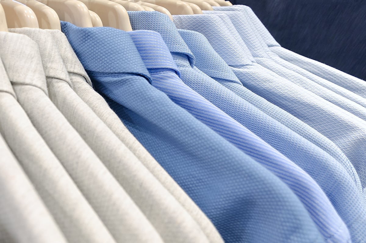white, blue, and light blue men's collared shirts on hangers